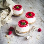 Cheesecake vegana allo yogurt in vasetti su tavolo di legno con cucchiaino