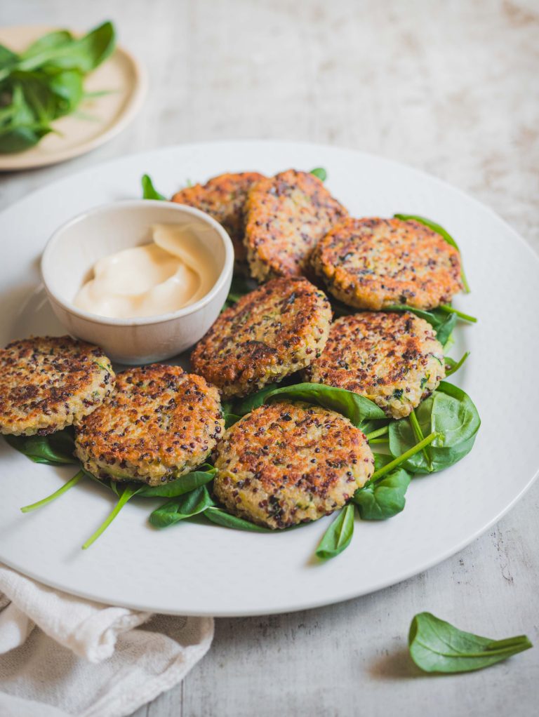 Crocchette di quinoa e zucchine in piatto bianco con ciotolina di maionese