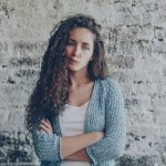 Ragazza con braccia incrociate che pensa a come relazionarsi con persone non vegane