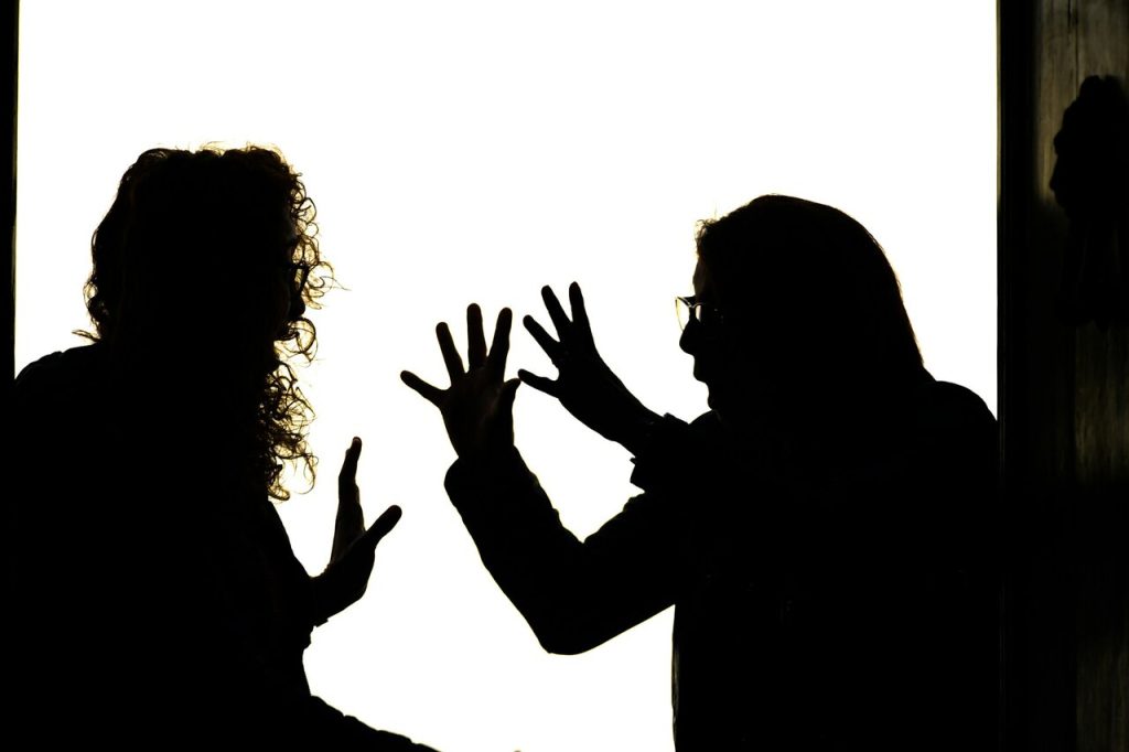 Due persone in penombra che discutono