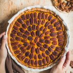 Pumpkin pie senza glutine in teglia rotonda su tavolo di legno e canovaccio marrone