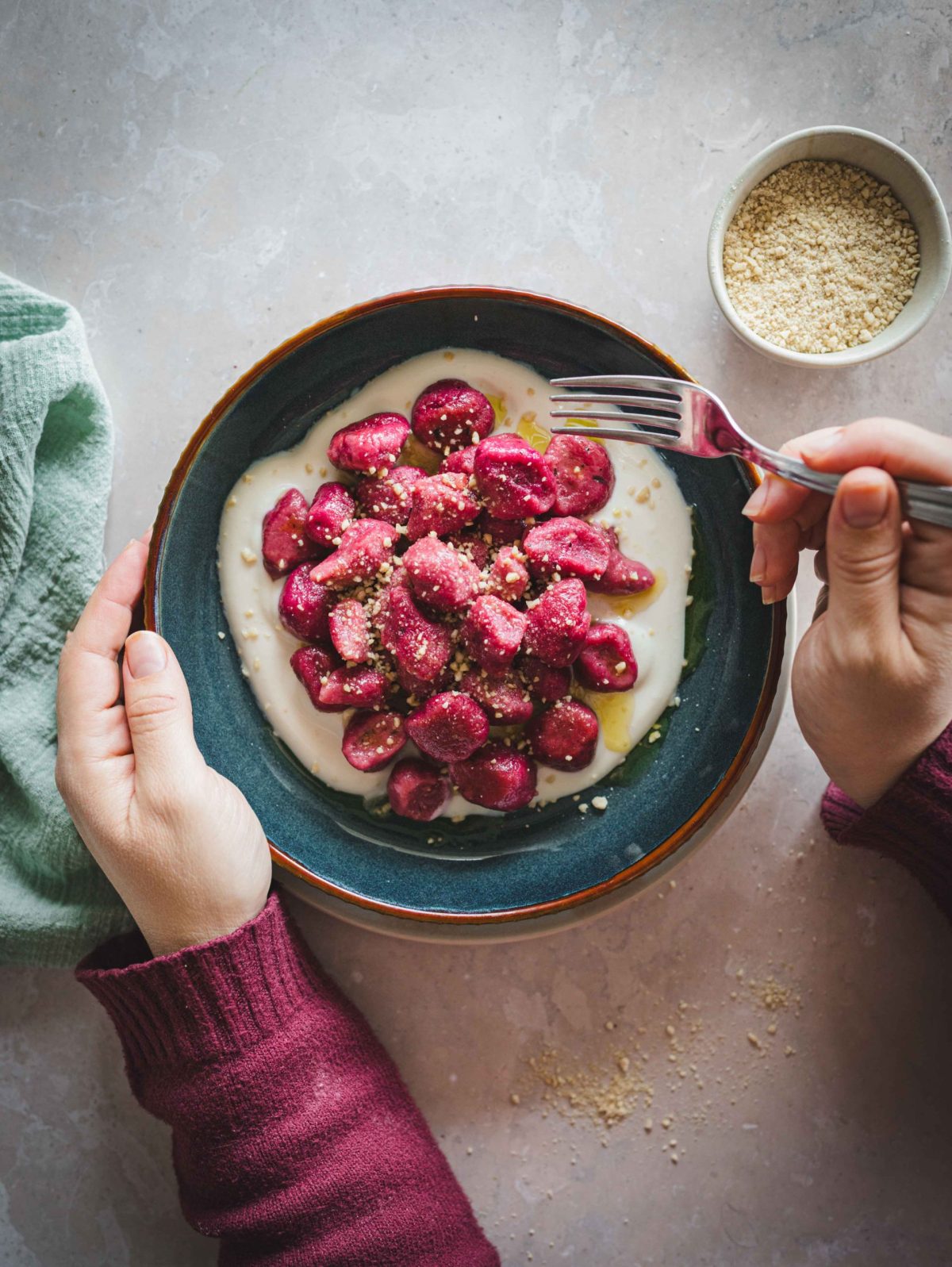 Gnocchi di barbabietola e patate su piatto fondo con base di panna vegetale