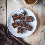 Vegan fudge al cioccolato fondente in piatto bianco su tavolo e canovaccio