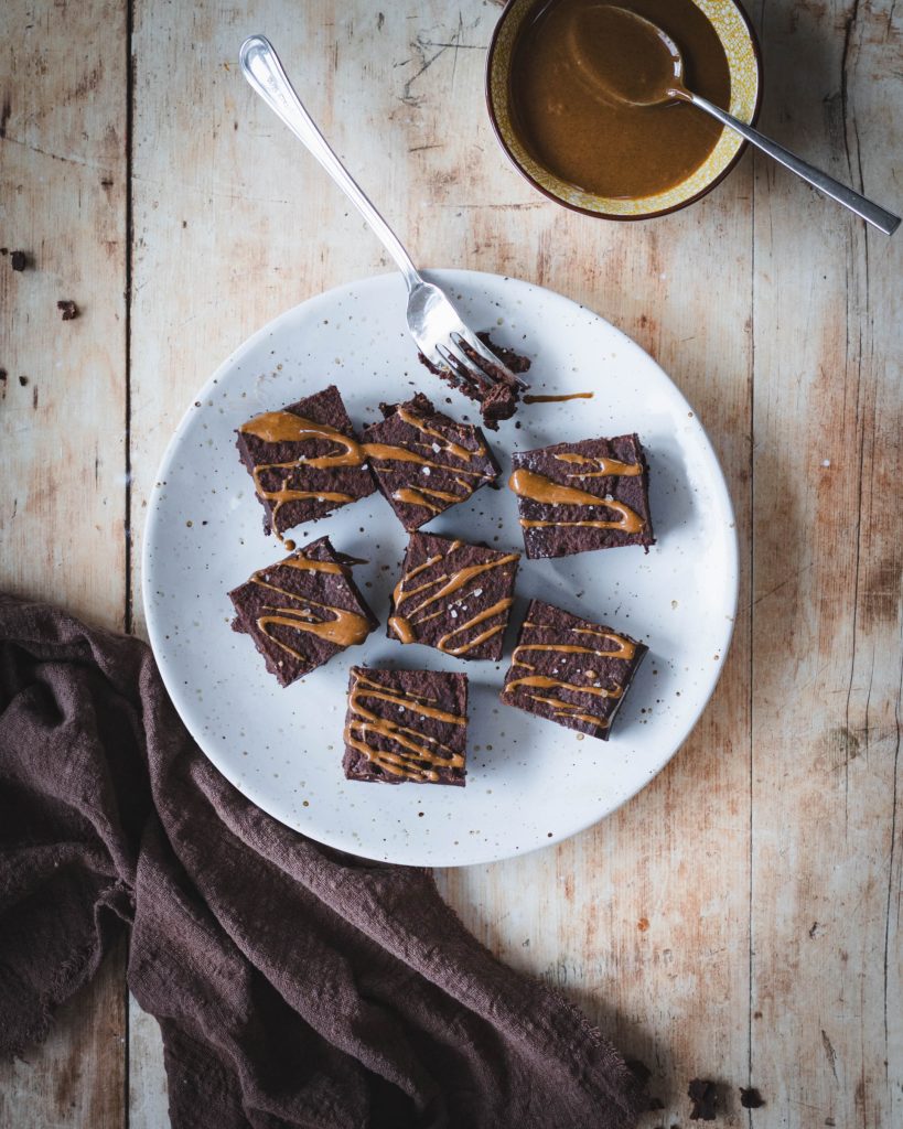 Vegan fudge al cioccolato fondente in piatto bianco su tavolo e canovaccio