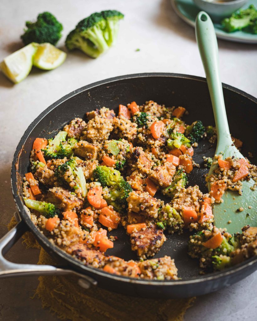 Padella con tempeh stir fry, quinoa e verdure con spatola