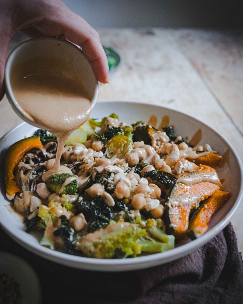 Piatto unico invernale con verdure e salsa da versare su piatto bianco